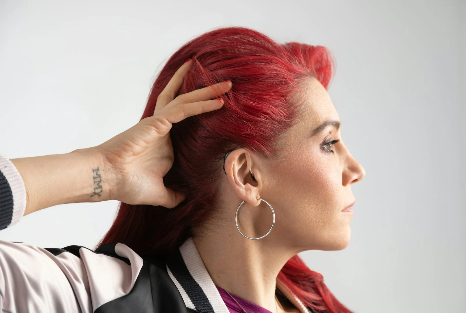 Julie Slavin mit roten Haaren und diskretem Hörgerät am Ohr